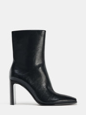 Black high-heel ankle boot with a sleek square toe, smooth leather-look finish, structured shaft, and slim stiletto heel.
