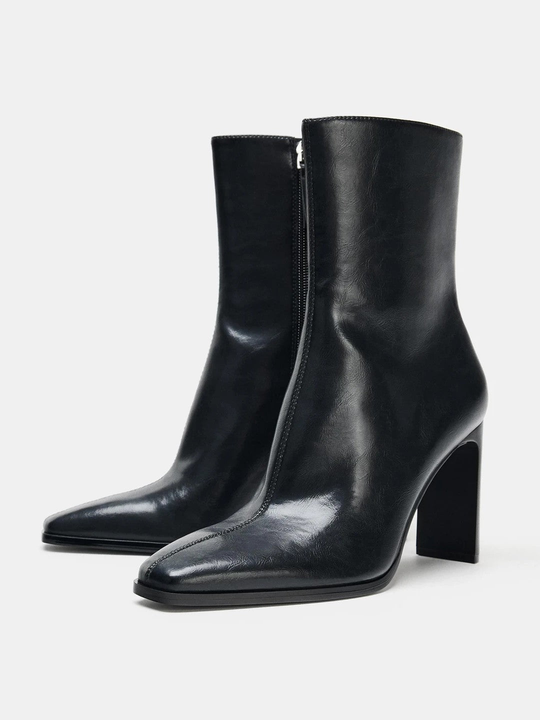 Black high-heel ankle boot with a sleek square toe, smooth leather-look finish, structured shaft, and slim stiletto heel.
