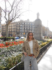 Cropped beige trench jacket worn buttoned