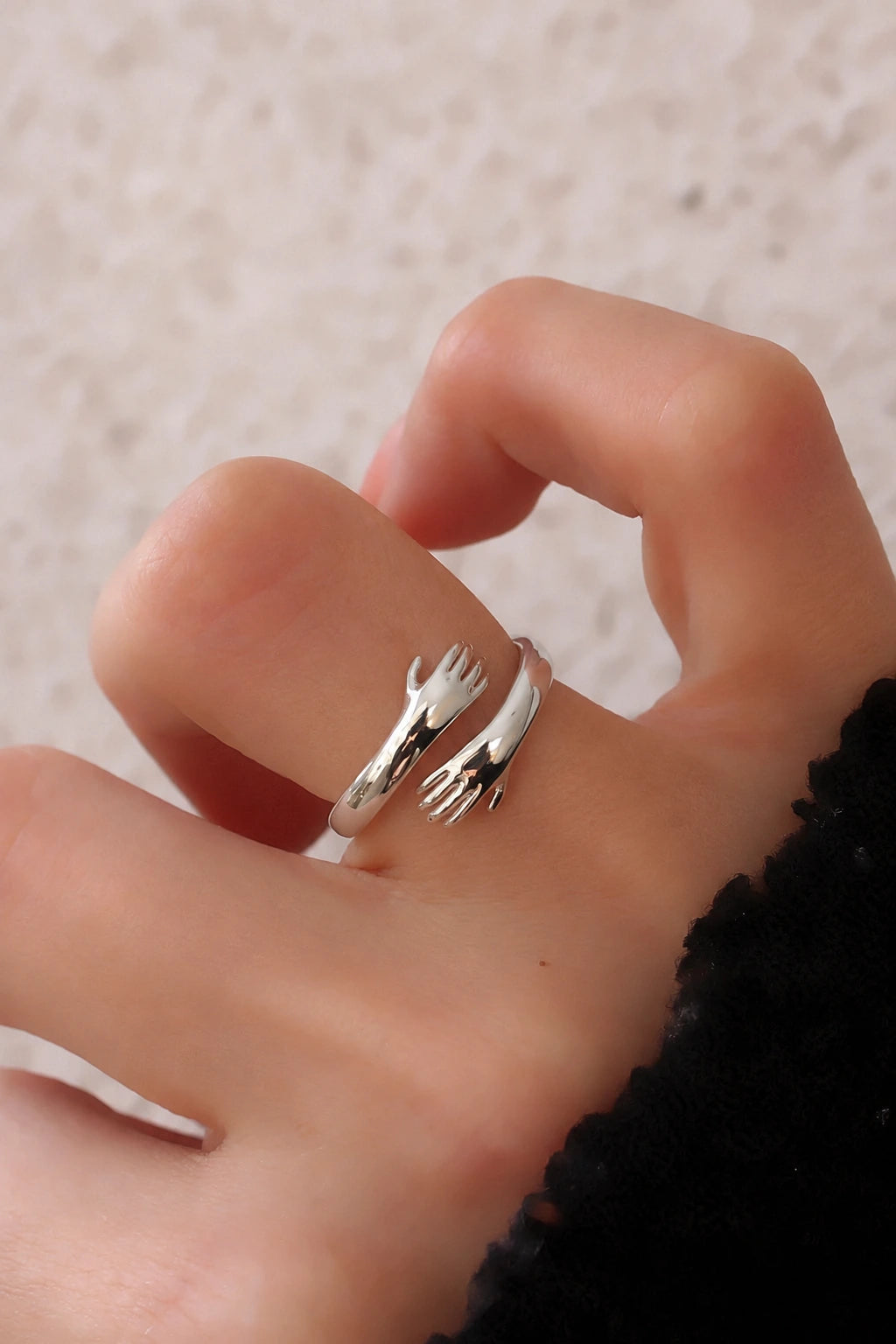 Anello Hug argentato: un unico anello aperto con due mani scolpite